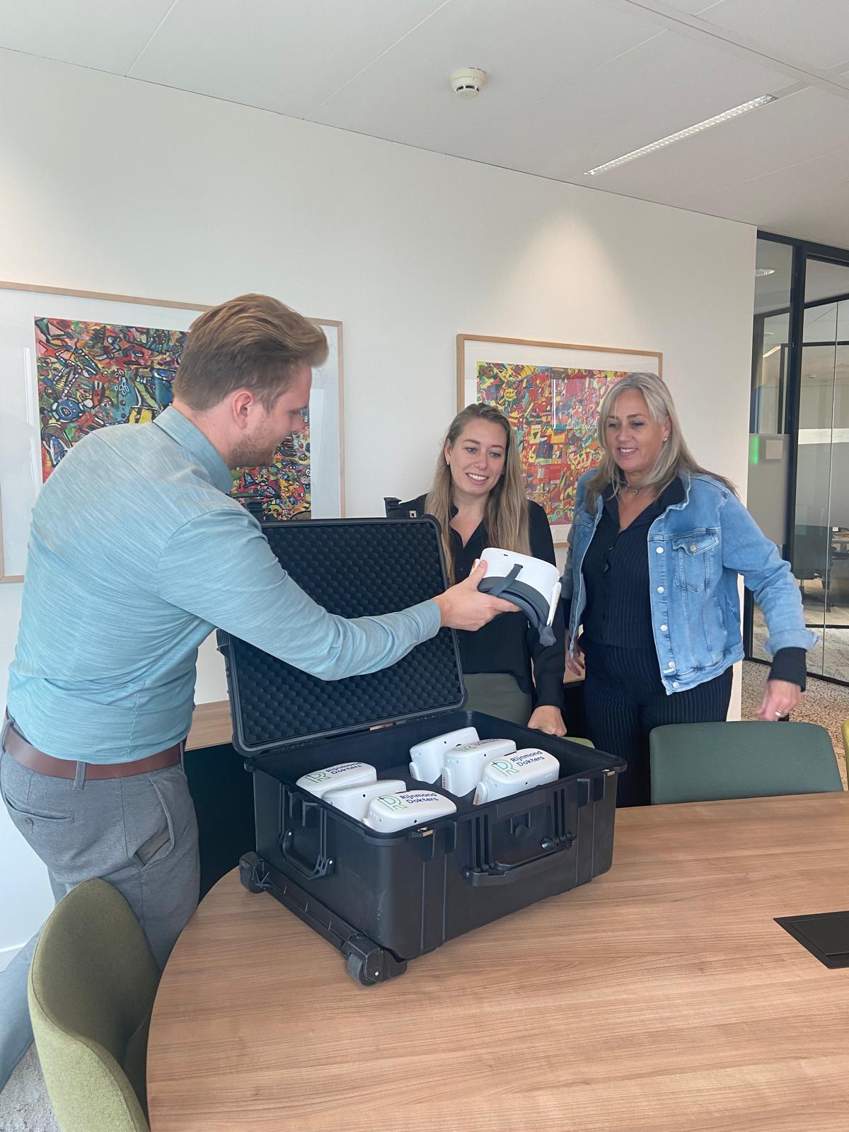 Jordi geeft vr brillen aan twee personen van Rijnmond Dokters